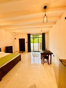 a bedroom with a bed and a desk and a table at Ru Retreat Weligama in Weligama