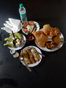 einen Tisch mit Teller mit Speisen darüber in der Unterkunft KRAZYROOMS, Kaziranga in Kāziranga