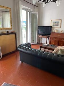 a living room with a black leather couch and a television at Villa Mirella in Numana