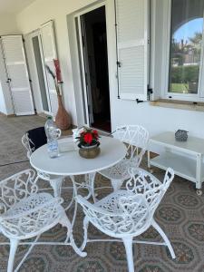 a white table and chairs with a vase of flowers on it at Villa Mirella in Numana