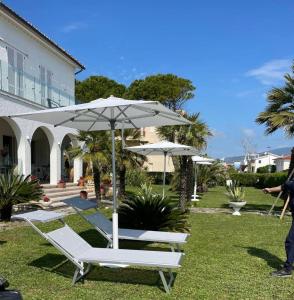 kilka leżaków i parasol w obiekcie Villa Mirella w mieście Numana