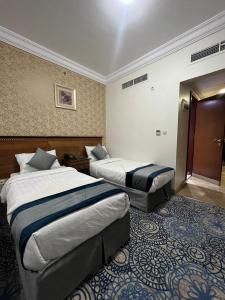 Un pat sau paturi într-o cameră la فندق إي دبليو جي العزيزية