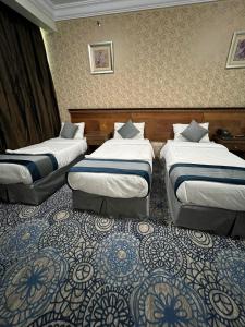 Ein Bett oder Betten in einem Zimmer der Unterkunft فندق إي دبليو جي العزيزية