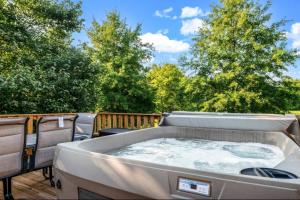 un bain à remous sur une terrasse avec des arbres en arrière-plan dans l'établissement Creekside Cottage*Hot Tub*Entire Home-Pigeon Forge, à Pigeon Forge