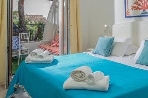 Zimmer mit Handtüchern auf einem Bett und einem Balkon in der Unterkunft Hotel Oriente in Vico Equense