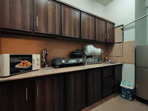 a kitchen with wooden cabinets and a microwave on a counter at APARTMENTS of Comfort! in Islamabad