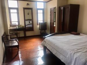 um quarto com uma cama e uma televisão em SJ House em Chiang Mai