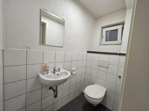 La salle de bains blanche est pourvue de toilettes et d'un lavabo. dans l'établissement Wohnreich Blaustein Mitte -1A- 2er WG, à Blaustein