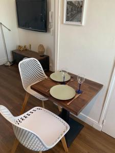 een tafel en twee stoelen met wijnglazen erop bij Studio cosy parking gratuit et à 5 minutes gare in Le Plessis-Bouchard