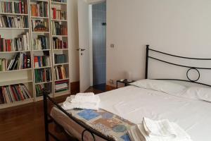 um quarto com uma cama e estantes de livros com livros em Luxury apartment big lounge fireplace 2 terraces B em Veneza