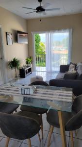 uma sala de estar com uma mesa de vidro e cadeiras em Henko House em Quepos