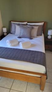 uma cama grande com lençóis brancos e almofadas em Henko House em Quepos