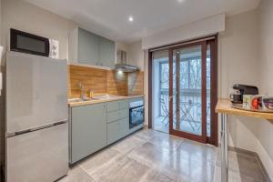 a kitchen with white appliances and a large window at Le Bellevue - Gare de Grenoble in Grenoble