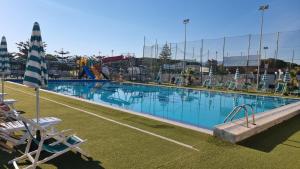 una grande piscina con sedie e ombrellone di Gargano Hotel Helios a Rodi Garganico