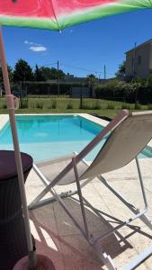 una sedia seduta sotto un ombrellone accanto alla piscina di Casa quinta Los Teros a Junín