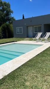 due sedie da giardino bianche sedute accanto a una casa di Casa quinta Los Teros a Junín