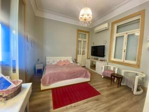 - une chambre avec un grand lit et une télévision dans l'établissement Cozy Room in Garden City for females, au Caire