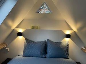 a bed with two pillows in a room with a window at Cottage Guest House in Wassenaar in Wassenaar