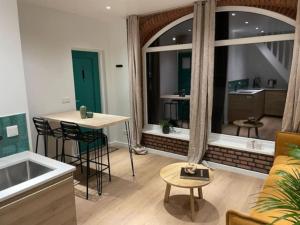 a living room with a large window and a table at Cottage Guest House in Wassenaar in Wassenaar