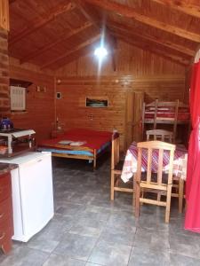 a room with a kitchen and a bed in a cabin at Escapada Natural Bungalows El Pindó in General Alberdi