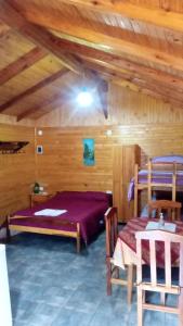a room with two beds in a wooden room at Escapada Natural Bungalows El Pindó in General Alberdi