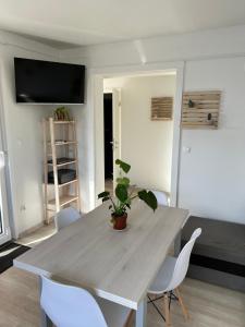 a dining room with a table and white chairs at Holiday Homes Ahil 7&8 in Pakoštane