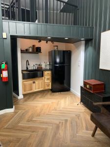 a kitchen with a black refrigerator and wooden floors at Chalet 239-Boutique Hotel in West Dover