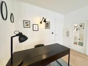 a black desk with a black lamp on a white wall at Luxueux 3 pièces 80m2 - Espace bureau -1mn Beach Croisette in Cannes