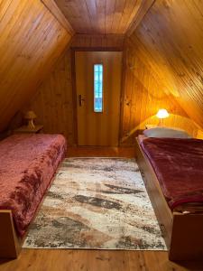 a bedroom with two beds in a wooden room at Domek na Polance in Rajcza