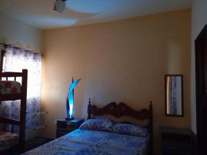 a bedroom with a bed with a lamp on it at Casa em Cabo Frio in Cabo Frio