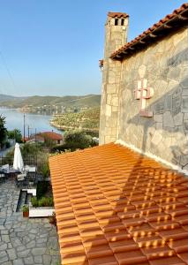 un edificio con techo de baldosa con un cartel. en Art Hotel Panorama, en Pyrgadikia