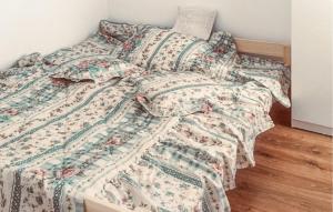 una camera con un letto e un piumone floreale di 4 Bedroom Lovely Home In Rybical a Ryn