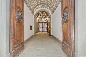 un pasillo con 2 grandes puertas de madera en un edificio en Tornabuoni Living - Luxury Apartments Collection en Florence