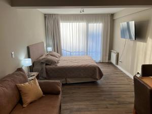 a hotel room with a bed and a couch at Guemes 540 Studio in San Carlos de Bariloche