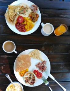 two plates of breakfast food on a wooden table at Hotel The Rich Grand Agra in Agra