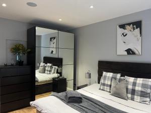 1 dormitorio con cama y espejo grande en The Broadway Beach House with Hot tub, en Kent