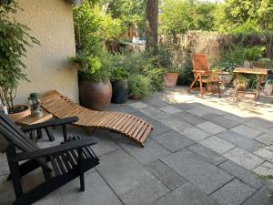 un patio con banco, mesas y sillas en Boutique Apartments Benz I-III, en Bergisch Gladbach