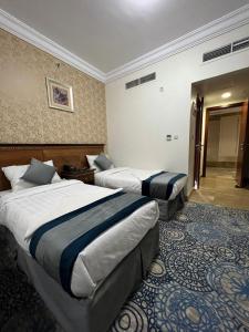 Ένα ή περισσότερα κρεβάτια σε δωμάτιο στο فندق إي دبليو جي العزيزية