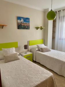 a bedroom with two beds and a painting on the wall at SUEÑOS DEL MAR in Motril