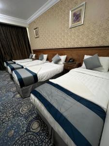 Un pat sau paturi într-o cameră la فندق إي دبليو جي العزيزية