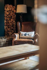 uma cadeira castanha com uma almofada num quarto com lareira em Fontain House: 4 bedroom Victorian villa em Blairgowrie