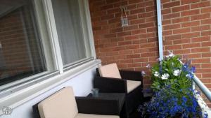 a porch with two chairs and a plant with flowers at City Apartment Snellmaninkatu 22 A, yksityinen pistokkeellinen paikoitus sisältyy hintaan in Kuopio