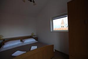 Habitación pequeña con cama y ventana en Apartment Jure, en Trogir