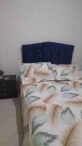 1 dormitorio con 1 cama con cabecero azul en El descanso, en Bogotá