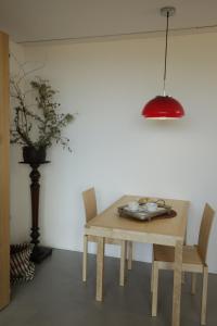 einem Holztisch mit zwei Stühlen und einer roten Lampe in der Unterkunft Gerês - Leiras do Tempo - Cottage Tomadinha 3 in Terras de Bouro