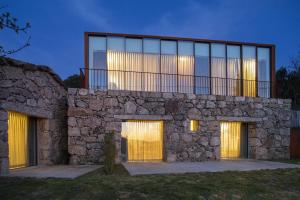 a stone house with a balcony on top of it at Gerês - Leiras do Tempo - Cottage Tomadinha 3 in Terras de Bouro