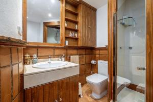 a bathroom with a sink and a toilet and a mirror at Lujo y comodidad en Sierra Nevada in Monachil