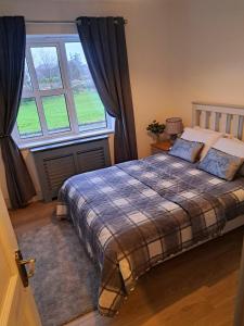 um quarto com uma cama e uma grande janela em Connemara Ocean Escape em Galway