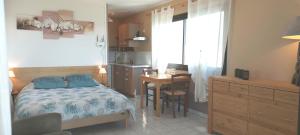 a bedroom with a bed and a table and a desk at Appartement vue panoramique 2 personnes Horizon in Millau
