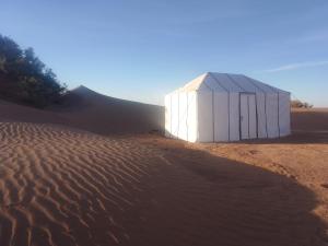 a white building in the middle of a desert at Nomad Life Style in Mhamid